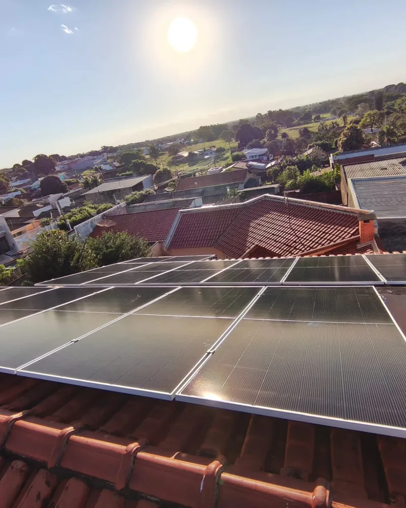 Painéis solares em telhado de telhas cerâmicas ao pôr do sol